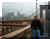 Marios on Brooklyn Bridge with the financial district behind him